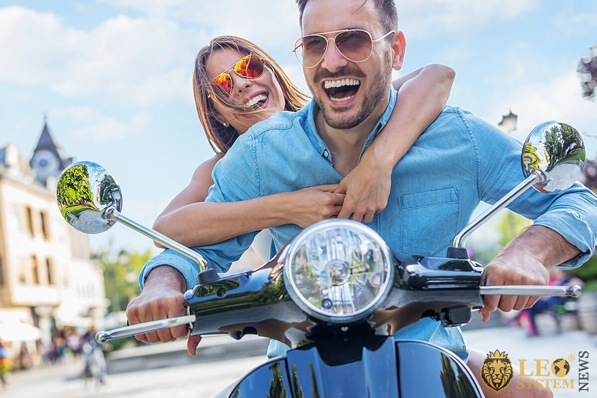 Male and a happy female riding a motorcycle