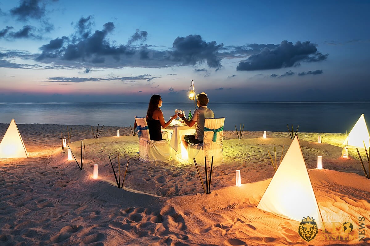Romantic evening of a couple on the sand by the sea
