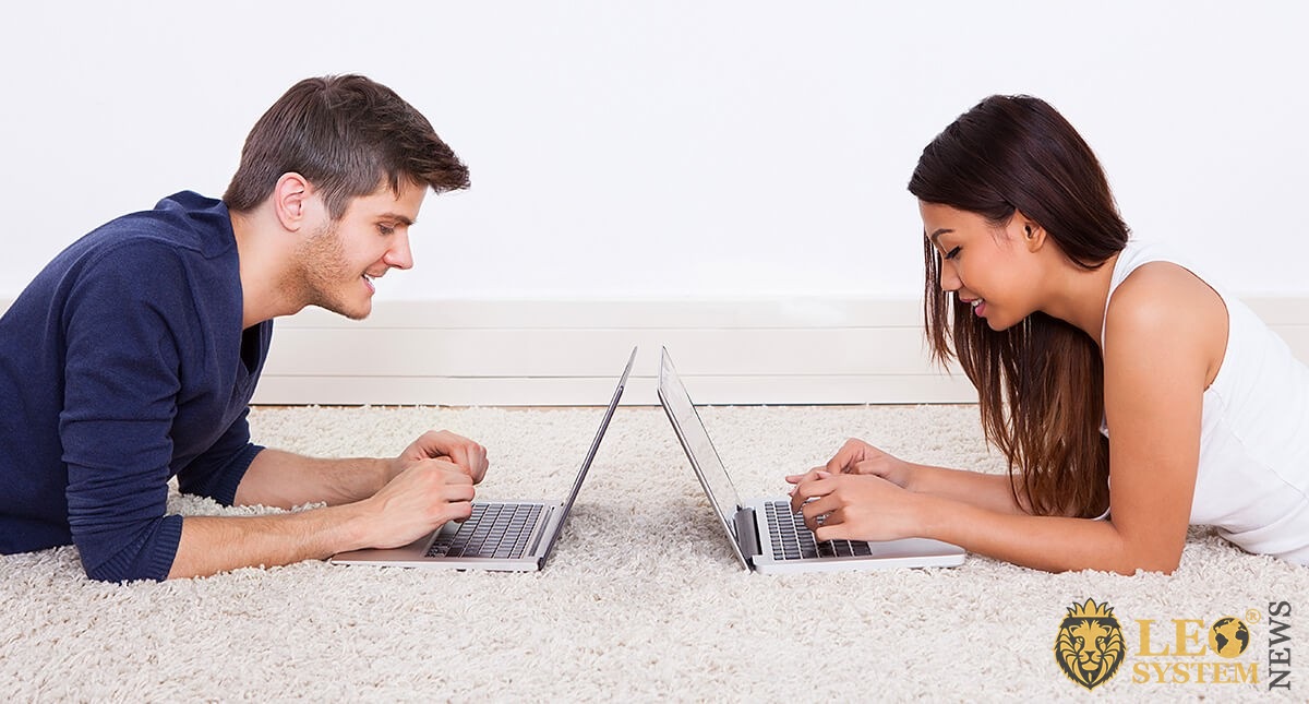 Girl and guy are lying with laptops