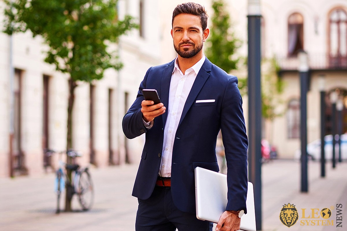 Image of a business man with a phone and laptop