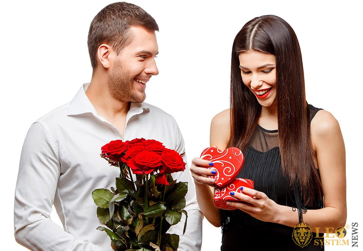 Loving man gives his woman flowers and a present
