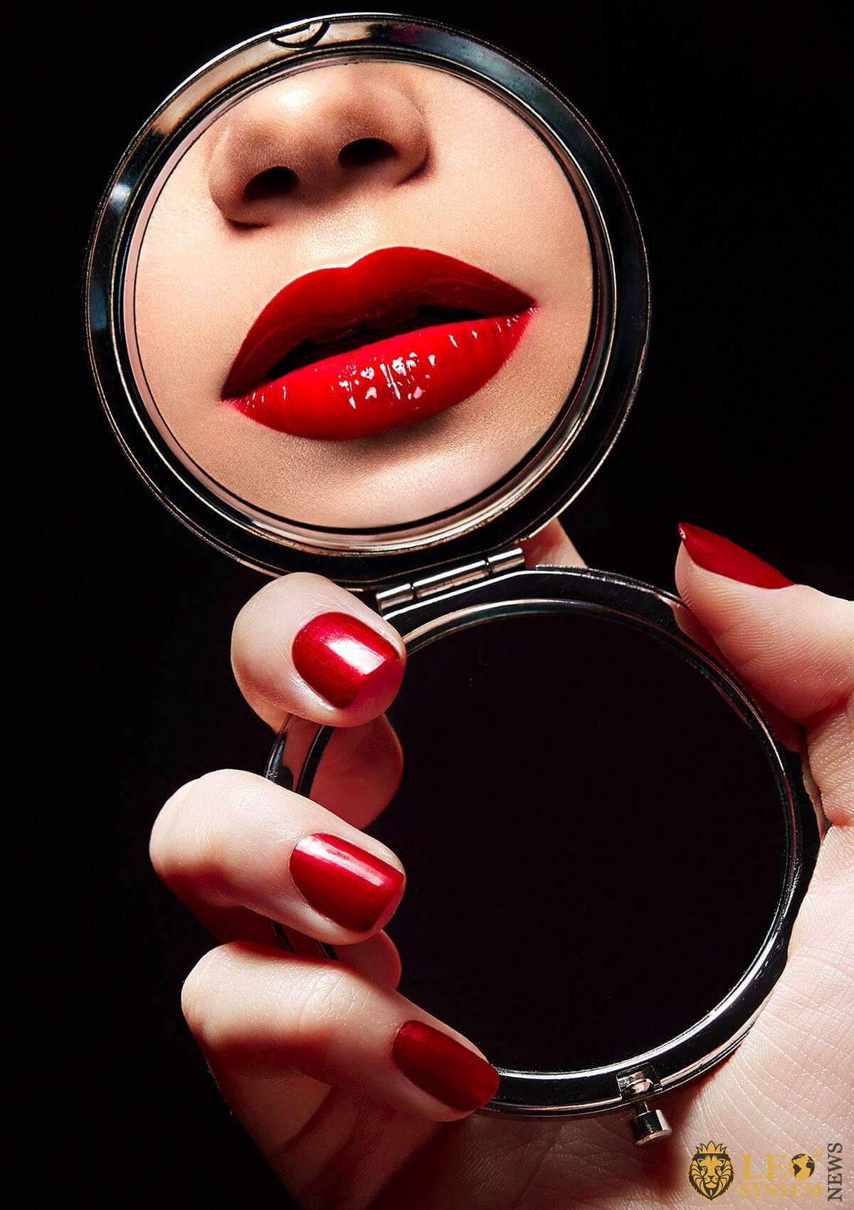 Girl looks in the mirror at her red lips