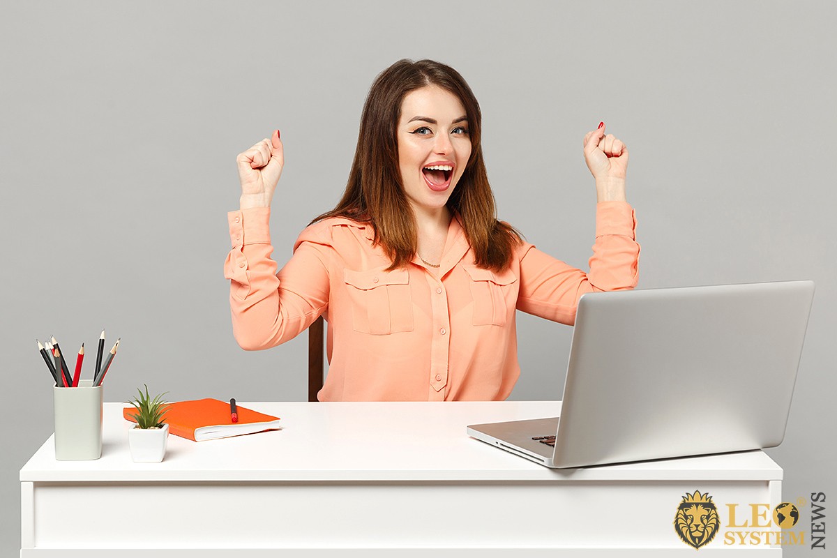 Image of joyful woman at work table in office