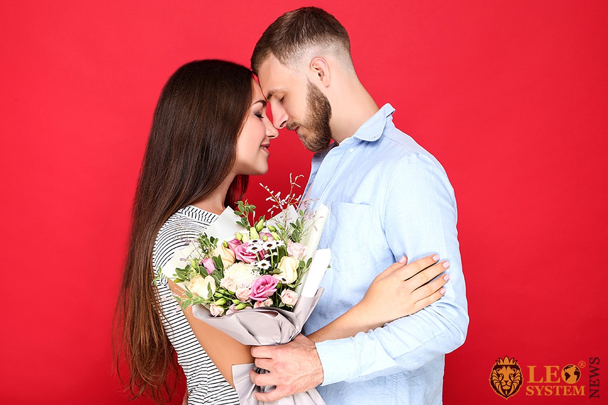 Photo of a couple in love with a bouquet of flowers