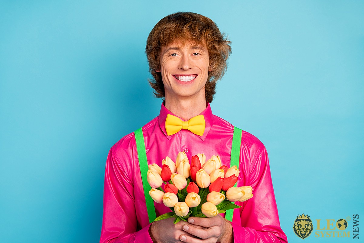 Image of a happy young man with a bouquet of flowers