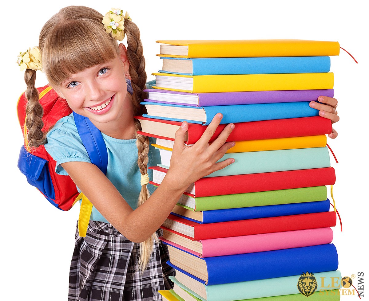 Cute girl with a lot of books in her hands