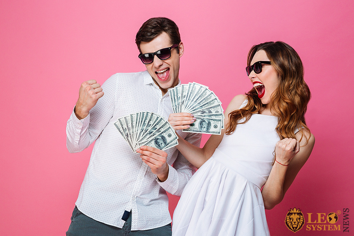 Cheerful couple with money in their hands